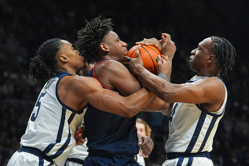 UConn forward Tarris Reed Jr. (5) fights for the ball with Butler forward Michael Ajayi (5) and forward Efeosa Oliogu-Elabor (4) in the first half of an NCAA college basketball game in Indianapolis, Wednesday, Feb. 11, 2026. (AP Photo/Michael Conroy)