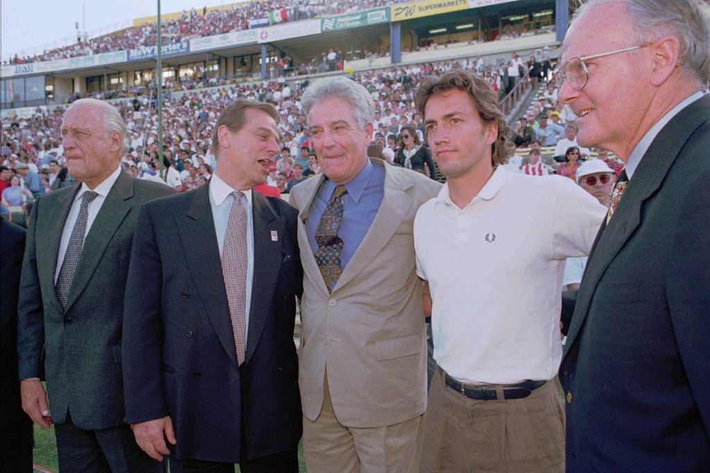 FILE - From right, Major League Soccer owners representative Lamar Hunt, actor Andrew Shue, Commissioner Douglas Logan, Chairman Alan Rothenberg, and FIFA representative Joao Havelange gather on the field before the start of the league's inaugural game in San Jose, Calif., April 6, 1996. (AP Photo/Craig Fujii, File)