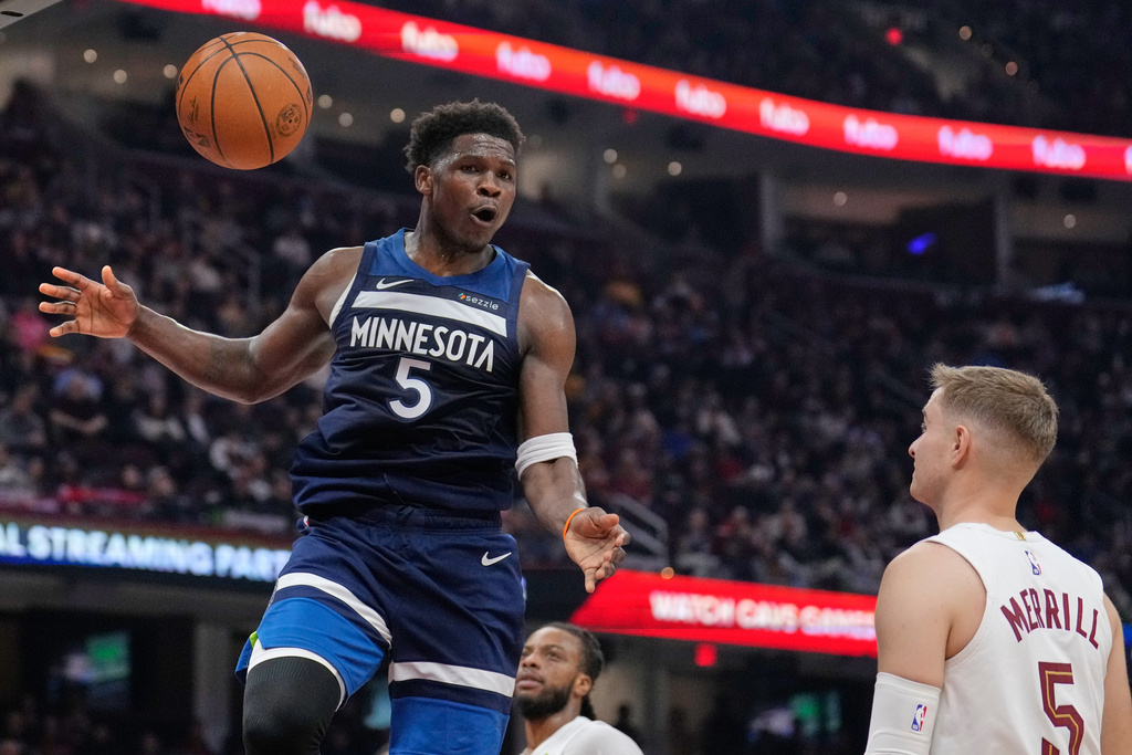 CORRECTS TO SATURDAY, JAN. 10, NOT SUNDAY, JAN. 4 - Minnesota Timberwolves guard Anthony Edwards (5) dunks in front of Cleveland Cavaliers guard Sam Merrill, right, in the first half of an NBA basketball game Saturday, Jan. 10, 2026, in Cleveland. (AP Photo/Sue Ogrocki)
