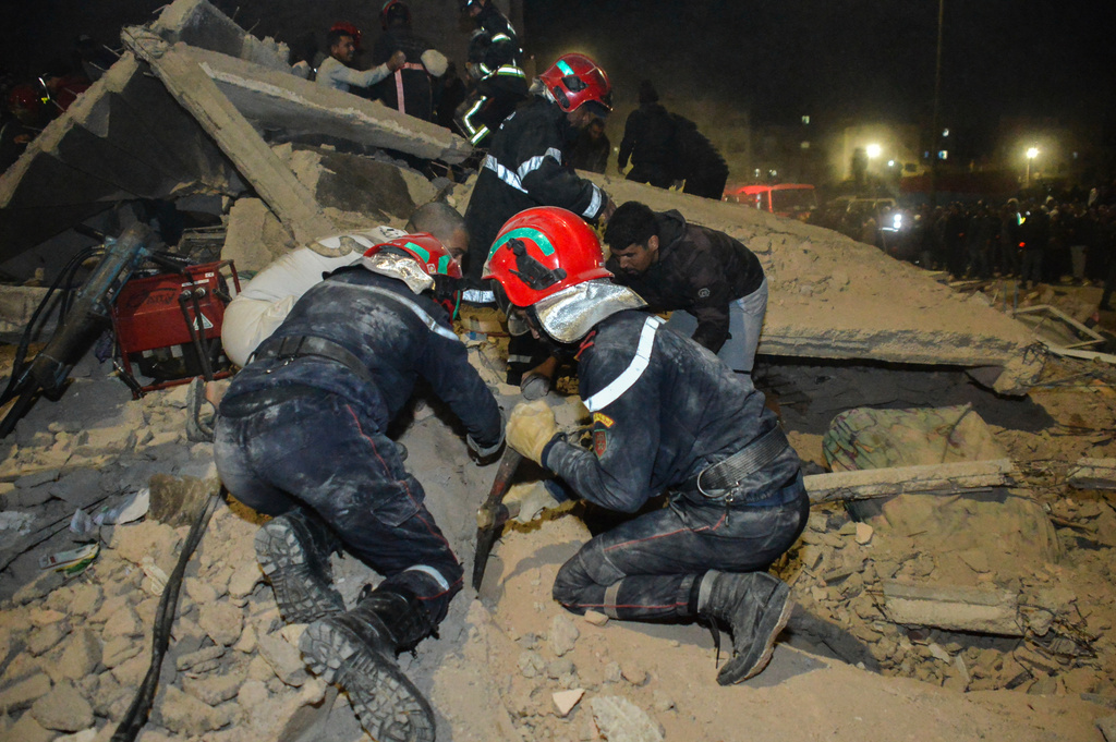 Rescue workers and residents search for survivors amid the wreckage of two collapsed buildings in Fez, Morocco, Tuesday, Dec. 9, 2025. (AP Photo/Ahmed Alaoui Mrani)