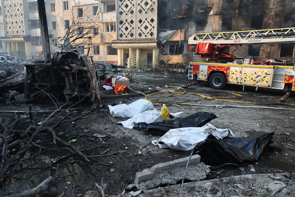 Dead bodies in plastic bags lie on the ground in front of residential building which was heavily damaged after a Russian strike on Ternopil, Ukraine, on Wednesday, Nov. 19, 2025. (AP Photo/Vlad Kravchuk)