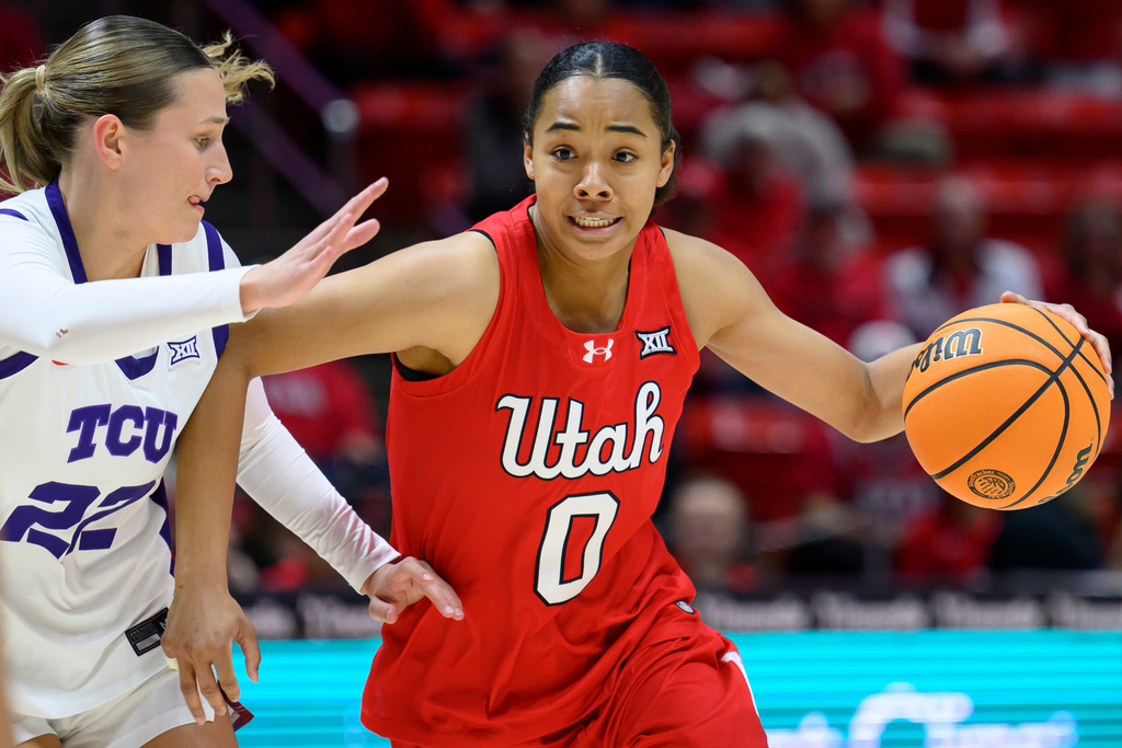 Utah guard Lani White (0) drives to the basket while guarded by TCU guard Maddie Scherr (22) during the first half of an NCAA college basketball game, Saturday, Jan. 3, 2026, in Salt Lake City. (AP Photo/Tyler Tate)