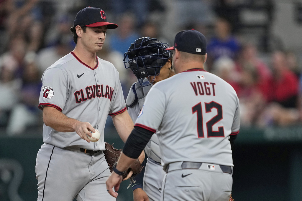 Cleveland Guardians starting pitcher Gavin Williams turns the ball over to manager Stephen Vogt (12) as he leaves the mound in the fourth inning of a baseball game against the Texas Rangers Sunday, Aug. 24, 2025, in Arlington, Texas. (AP Photo/Tony Gutierrez)