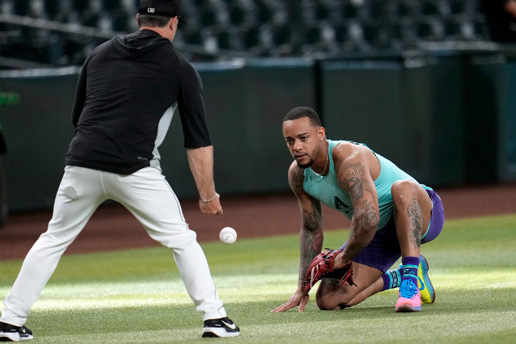 Returning Arizona Diamondbacks designated hitter Ketel Marte, right, fields grounders with Diamondbacks' Field Coordinator/Infield Coach Shaun Larkin prior to a baseball game against the Philadelphia Phillies, Monday, Aug. 31, 2026, in Phoenix. (AP Photo/Ross D. Franklin)