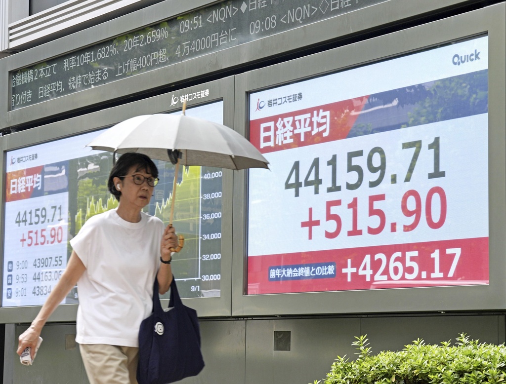 People walks past an electronic stock board showing Japan's Nikkei index at a securities firm Tuesday, Sept. 9, 2025, in Tokyo. (Kyodo News via AP)
