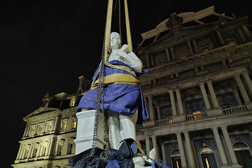 This photo provided by Will Hemsley shows a statue of Christopher Columbus being lowered into place at the Eisenhower Executive Office Building in Washington, Sunday, March 22, 2026. (Will Hemsley via AP)