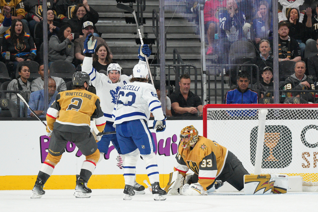 Toronto Maple Leafs center John Tavares, second from left, scores against Vegas Golden Knights goaltender Adin Hill (33) during the second period of an NHL hockey game Thursday, Jan. 15, 2026, in Las Vegas. (AP Photo/Candice Ward)