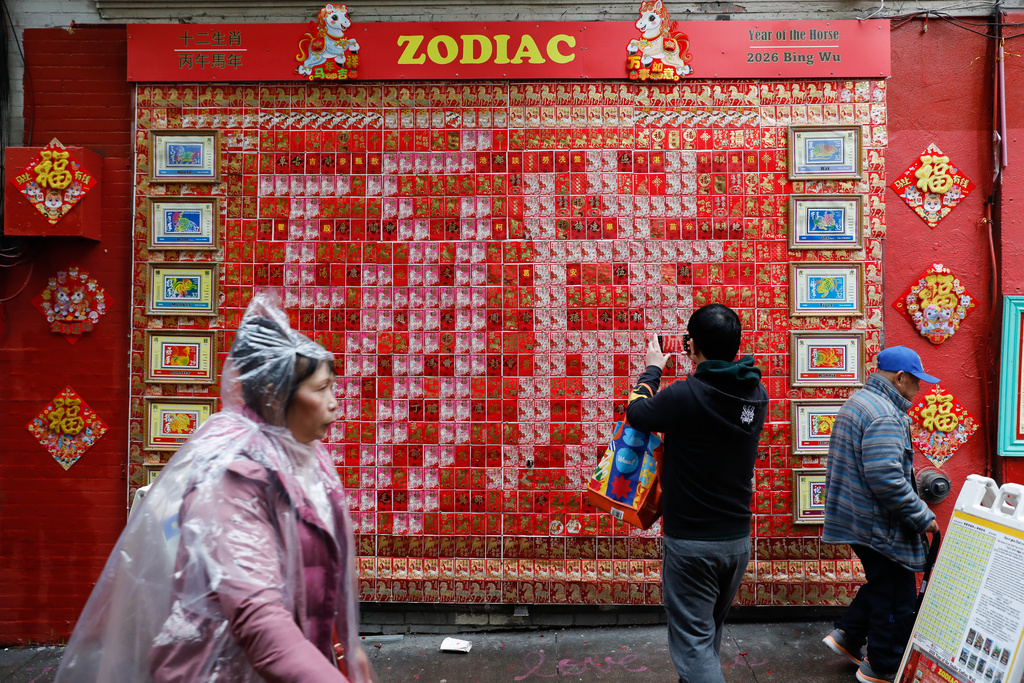 Pedestrians walk past the Zodiac Wall annoucing this year's Fire Horse during the annual Chinese New Year Day celebration, Community Good Fortune Walk, on Grant Avenue, along Jack Kerouac Alley in Chinatown, Tuesday, Feb. 17, 2026, in San Francisco. (Lea Suzuki/San Francisco Chronicle via AP)