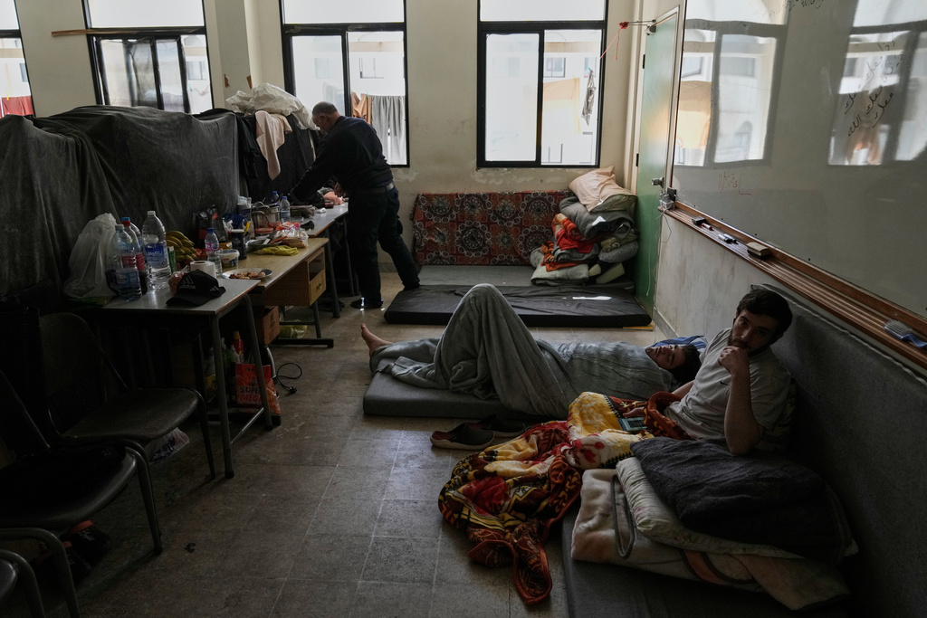 Displaced people fleeing Israeli airstrikes in southern Lebanon settle at the Bir Hassan Technical Institute, which has been turned into a shelter, in Beirut, Lebanon, Wednesday, March 11, 2026. (AP Photo/Bilal Hussein)
