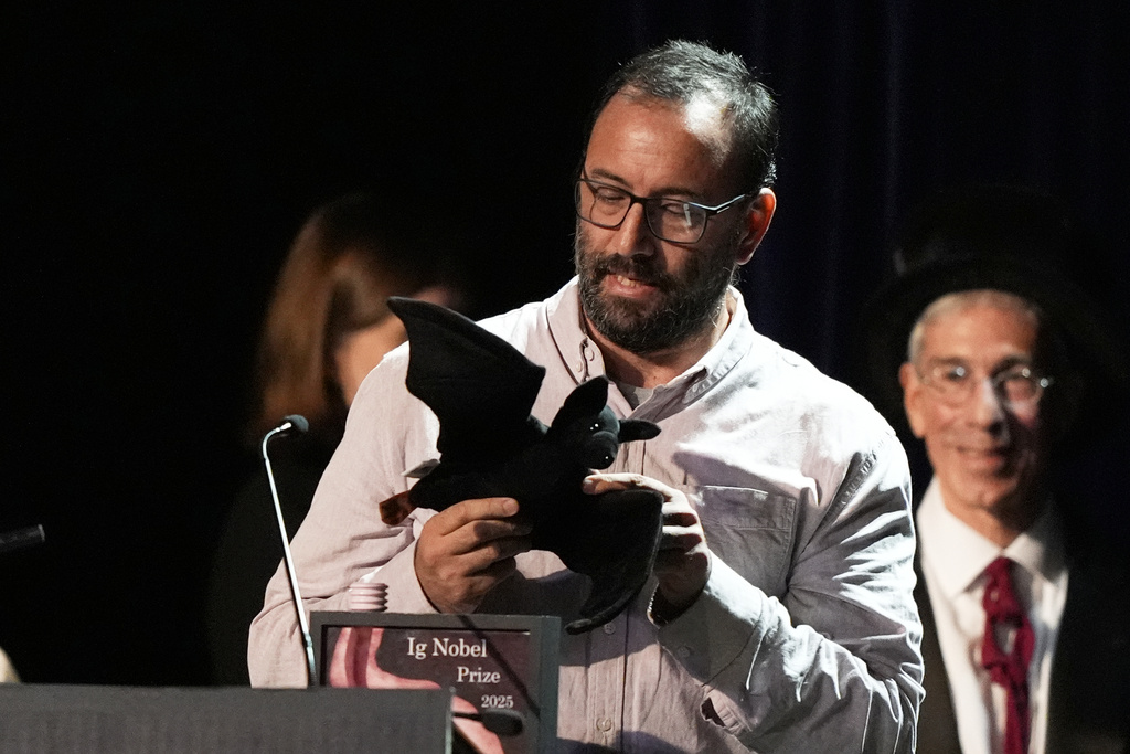 The Ig Nobel Prize for aviation is accepted by Francisco Sanchez for studying whether ingesting alcohol can impair bats' ability to fly, Thursday, Sept. 18, 2025, in Boston. (AP Photo/Robert F. Bukaty)