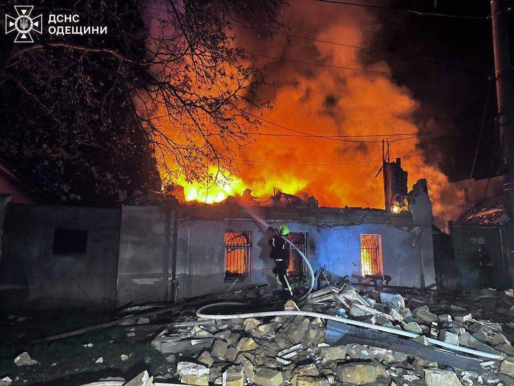 In this photo provided by the Ukrainian Emergency Services on Saturday, April 11, 2026, a rescue worker puts out a fire of residential house destroyed by a Russian drone strike on Odesa, Ukraine. (Ukrainian Emergency Service via AP)