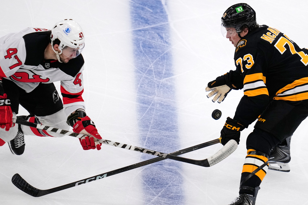 Boston Bruins defenseman Charlie McAvoy (73) and New Jersey Devils left wing Paul Cotter (47) battle for the puck during the second period of a hockey game, Tuesday, April 14, 2026, in Boston. (AP Photo/Charles Krupa)