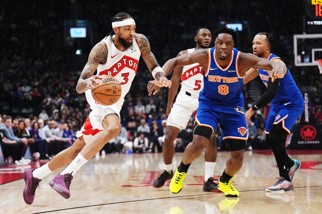 Toronto Raptors' Brandon Ingram (3) drives past New York Knicks' Og Anunoby (8) during first half NBA basketball action in Toronto on Tuesday, March 3, 2026. (Nathan Denette/The Canadian Press via AP)