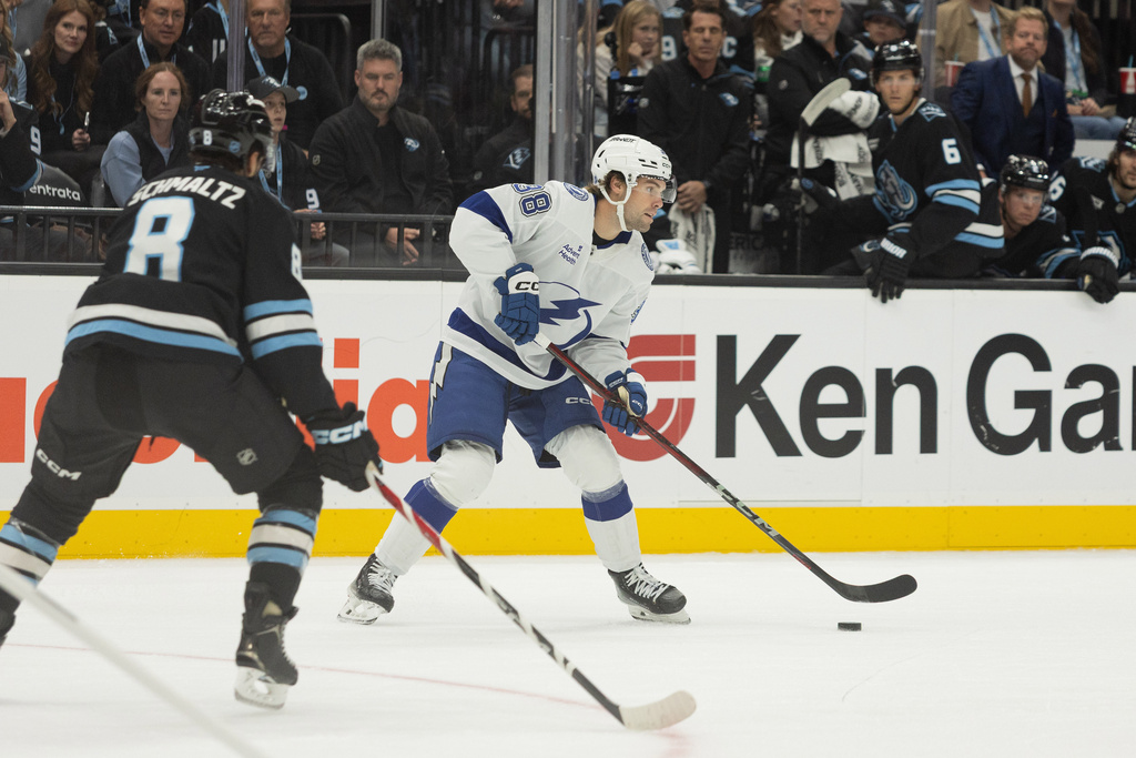 Tampa Bay Lightning left wing Brandon Hagel (38) moves the puck against Utah Mammoth right wing Nick Schmaltz (8) during the first period of an NHL hockey game Sunday, Nov. 2, 2025, in Salt Lake City. (AP Photo/Melissa Majchrzak)