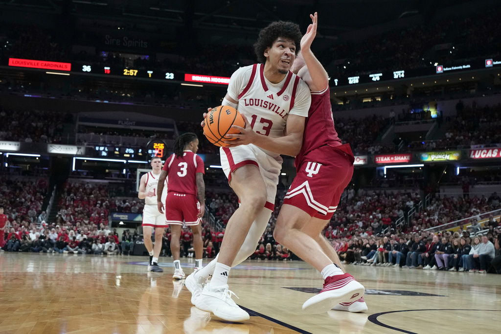 Louisville guard Ryan Conwell, left, moves to the shoot against Indiana forward Tucker Devries during an NCAA college basketball game in Indianapolis, Saturday, Dec. 6, 2025. (AP Photo/AJ Mast)