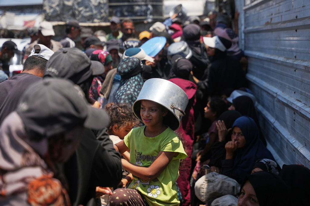 Displaced Palestinians lineup to receive donated food at a community kitchen in Khan Younis, southern Gaza Strip, Thursday, July 23, 2026. (AP Photo/Abdel Kareem Hana)