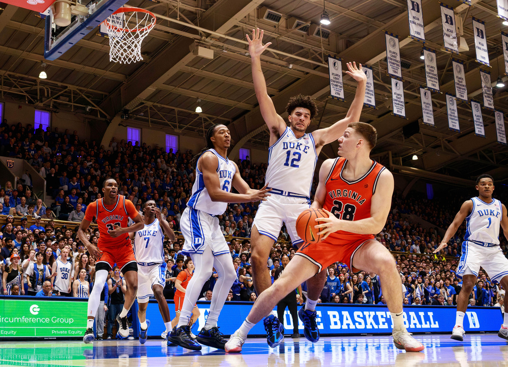 Virginia's Thijs De Ridder (28) handles the ball as Duke's Cameron Boozer (12) and Maliq Brown (6) defend during the first half of an NCAA college basketball game in Durham, N.C., Saturday, Feb. 28, 2026. (AP Photo/Ben McKeown)