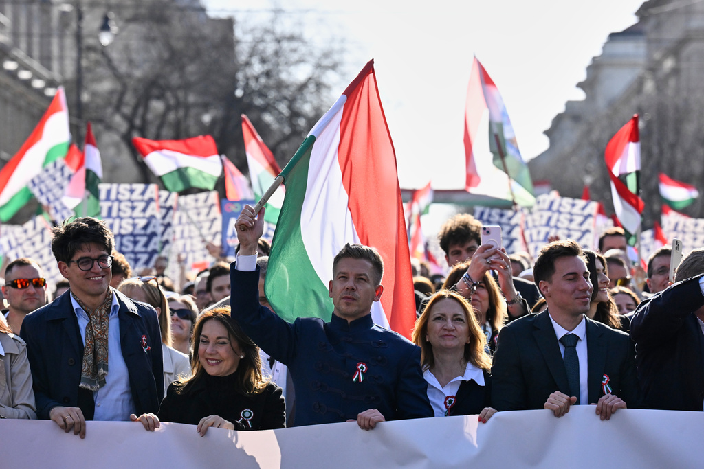 Opposition leader Peter Magyar, center, waves a flag during a march in Budapest, Hungary, Sunday, March 15, 2026. (AP Photo/Denes Erdos)