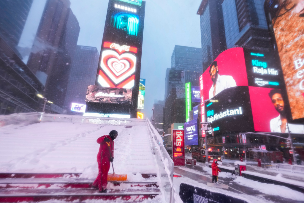 A worker with the Times Square Alliance sanitation crew clears snow from the Red Stairs in Times Square, Monday, Feb. 23, 2026, in New York. (AP Photo/Seth Wenig)