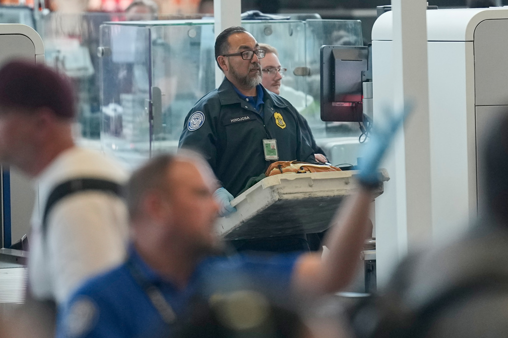 TSA officers work at a security checkpoint at George Bush Intercontinental Airport Friday, March 27, 2026, in Houston. (AP Photo/David J. Phillip)