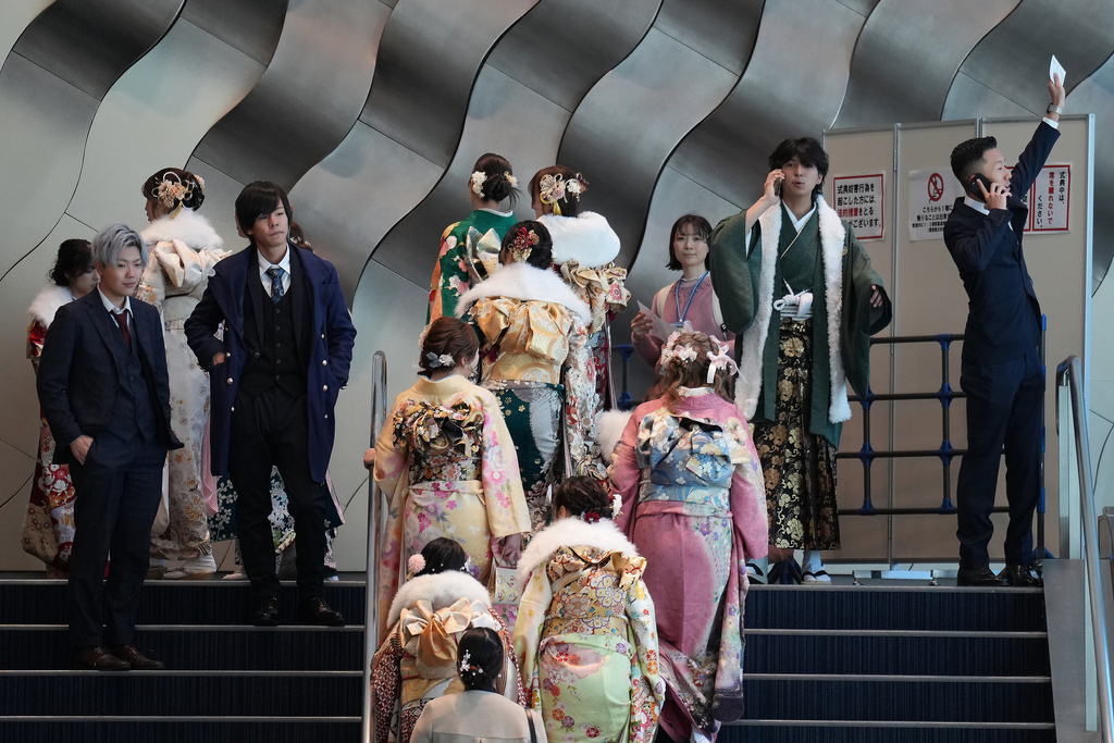 Young adults arrive at a venue to celebrate the Coming-of-Age Day, a centuries-old tradition and national holiday marking the milestone from childhood to adulthood, Monday, Jan. 12, 2026, in Yokohama near Tokyo. (AP Photo/Eugene Hoshiko)