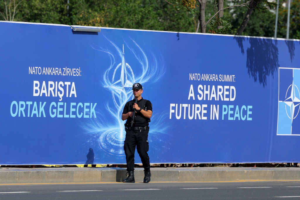 Police patrol in front of a banner ahead of the NATO Summit in Ankara, Turkey, Sunday, July 5, 2026. (AP Photo/Riza Ozel)