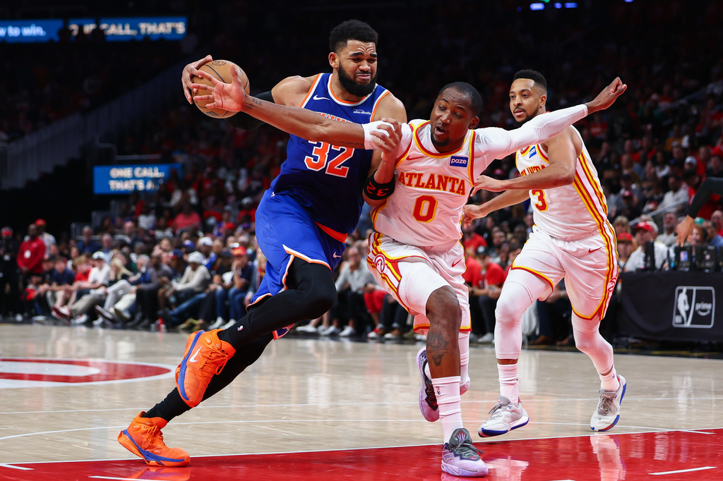 New York Knicks center Karl-Anthony Towns (32) drives to the basket against Atlanta Hawks forward Jonathan Kuminga (0) during the second half in Game 3 of a first-round NBA playoffs basketball series, Thursday, April 23, 2026, in Atlanta. (AP Photo/Colin Hubbard)