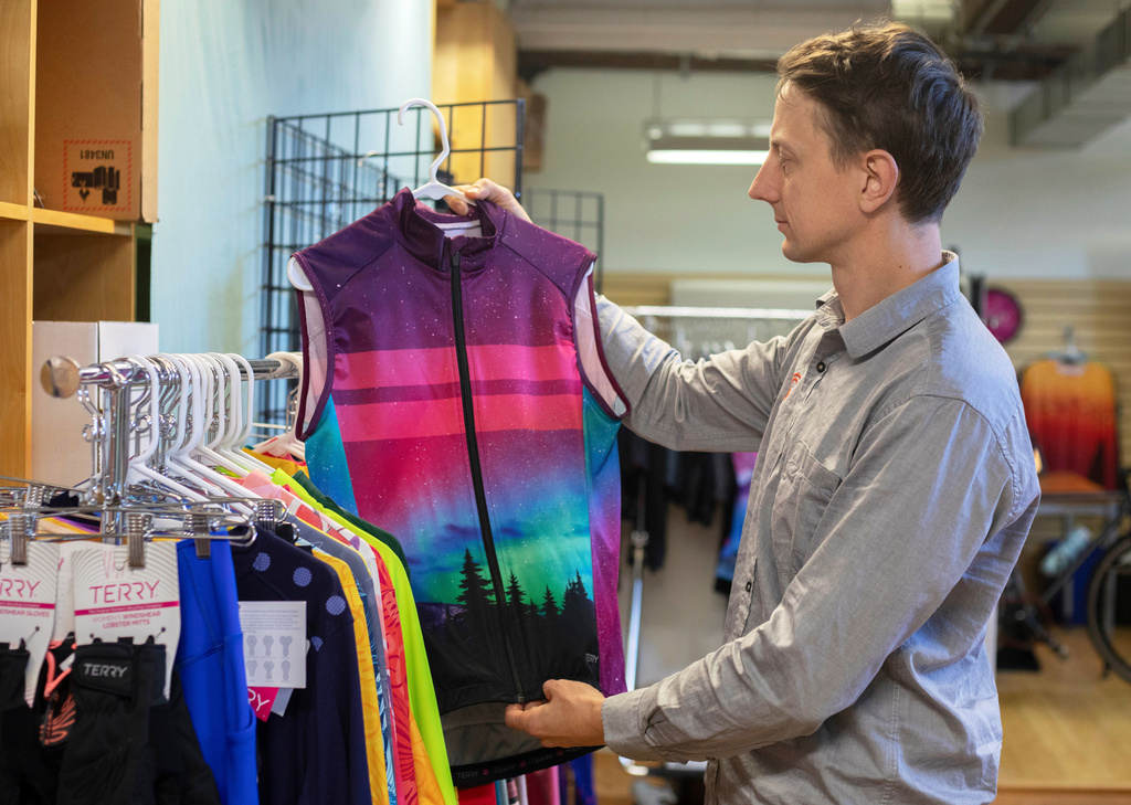 Terry Precision Cycling President Nik Holm, inspects a bike shirt at the company’s headquarters in Burlington, Vt., Tuesday, Oct. 28, 2025. (AP Photo/Amanda Swinhart)