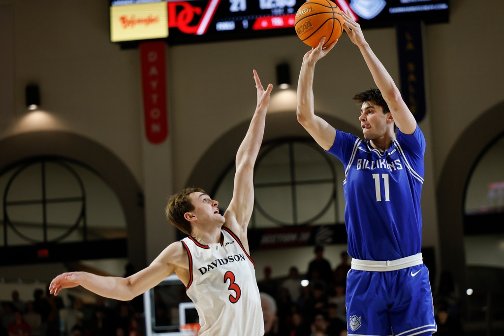 Saint Louis forward Brady Dunlap (11) shoots a jump shot against Davidson guard Nick Coval during the first half of an NCAA college basketball game in Davidson, N.C., Tuesday, Feb. 3, 2026. (AP Photo/Nell Redmond)