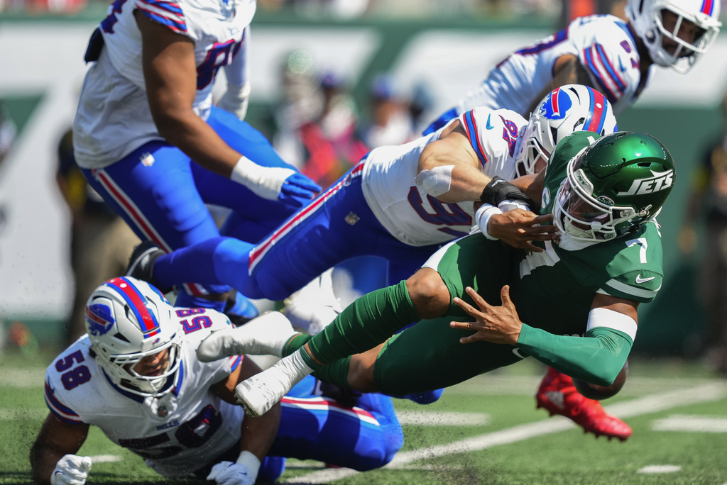 New York Jets quarterback Justin Fields (7) fumbles the ball as he's tackled by Buffalo Bills linebacker Matt Milano (58) and defensive end Joey Bosa (97) during the first quarter of an NFL football game, Sunday, Sept. 14, 2025, in East Rutherford, N.J. (AP Photo/Yuki Iwamura)