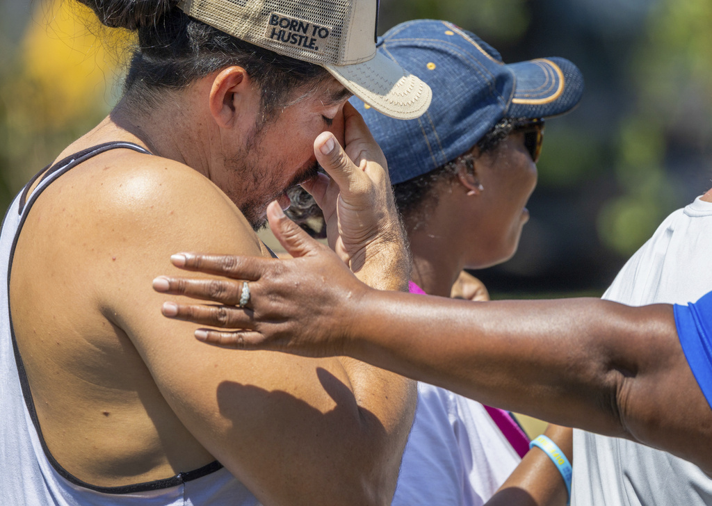 Friends and neighbors console each other as they gather near where 12-year-old Bryan Vasquez was found dead in a canal, Tuesday, Aug. 26, 2025, in New Orleans East. (Chris Granger/The Times-Picayune/The New Orleans Advocate via AP)