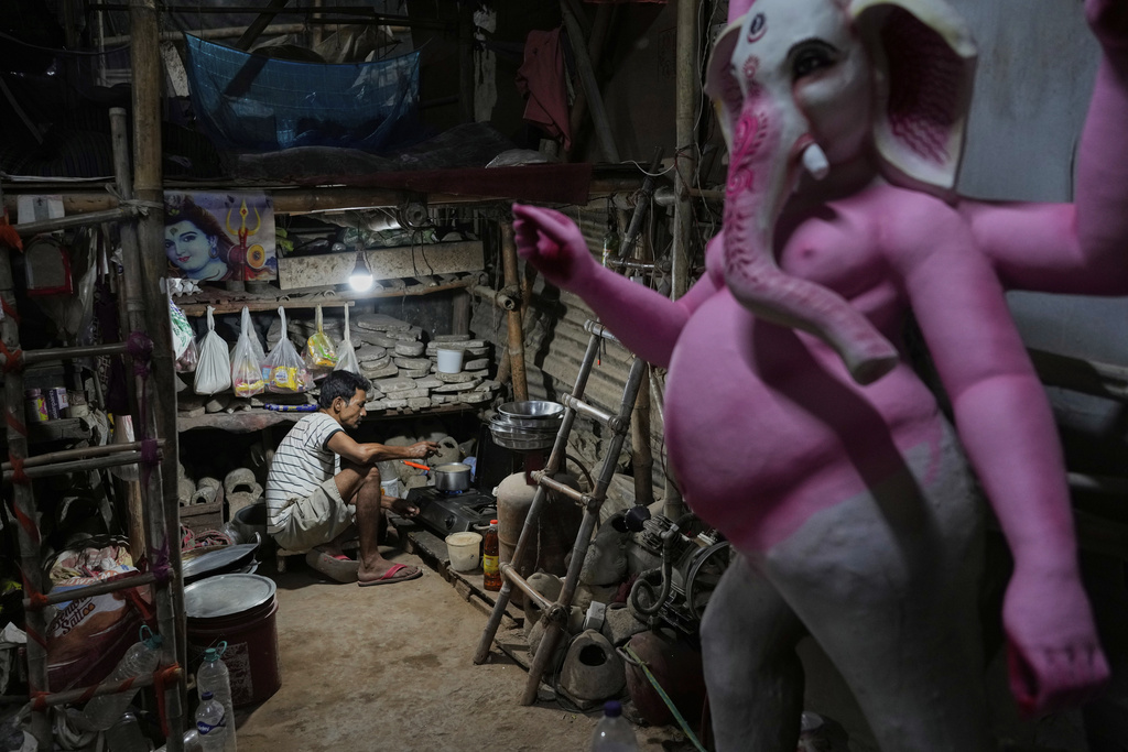 A worker makes tea for fellow artists who are creating idols of Hindu deities ahead of the Durga Puja festival in New Delhi, India, Friday, Sept. 19, 2025. (AP Photo/Manish Swarup)