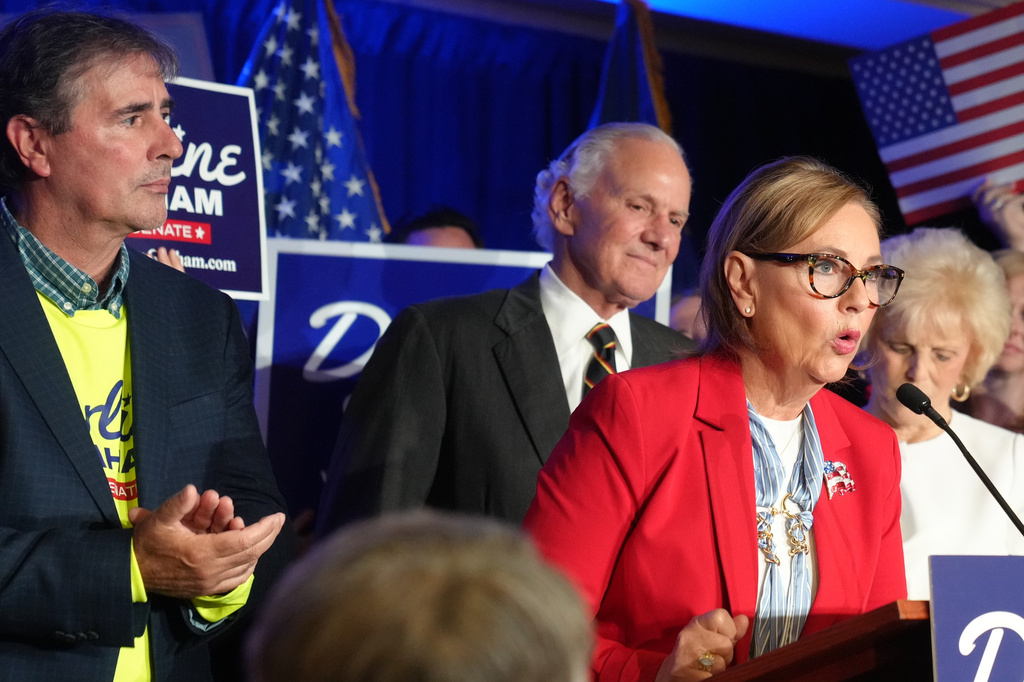 From left, Larry Nordone and Gov. Henry McMaster, R-S.C., look on as Sen. Darline Graham, R-S.C., gives a speech to supporters after winning a special Republican primary runoff to replace her brother in the November general election, Tuesday, Aug. 25, 2026, in Columbia, S.C. (AP Photo/Meg Kinnard)