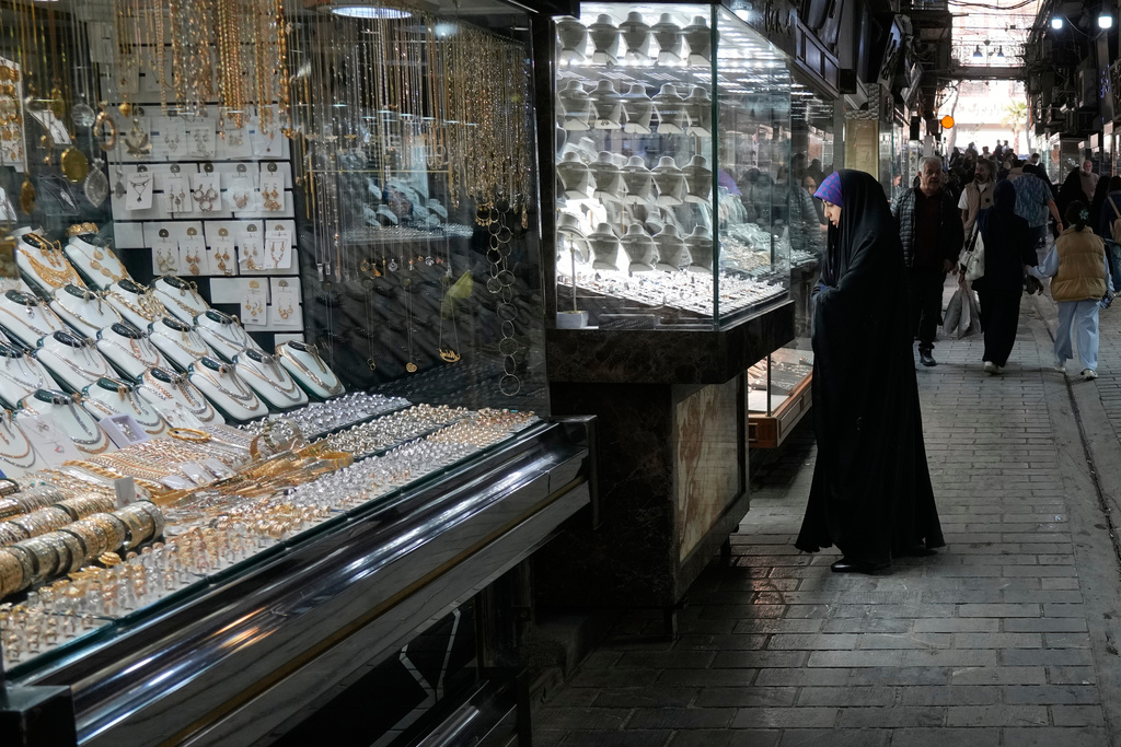 A woman looks at the window of a gold shop at a gold market in Tehran's Grand Bazaar, Iran, Saturday, Nov. 29, 2025. (AP Photo/Vahid Salemi)