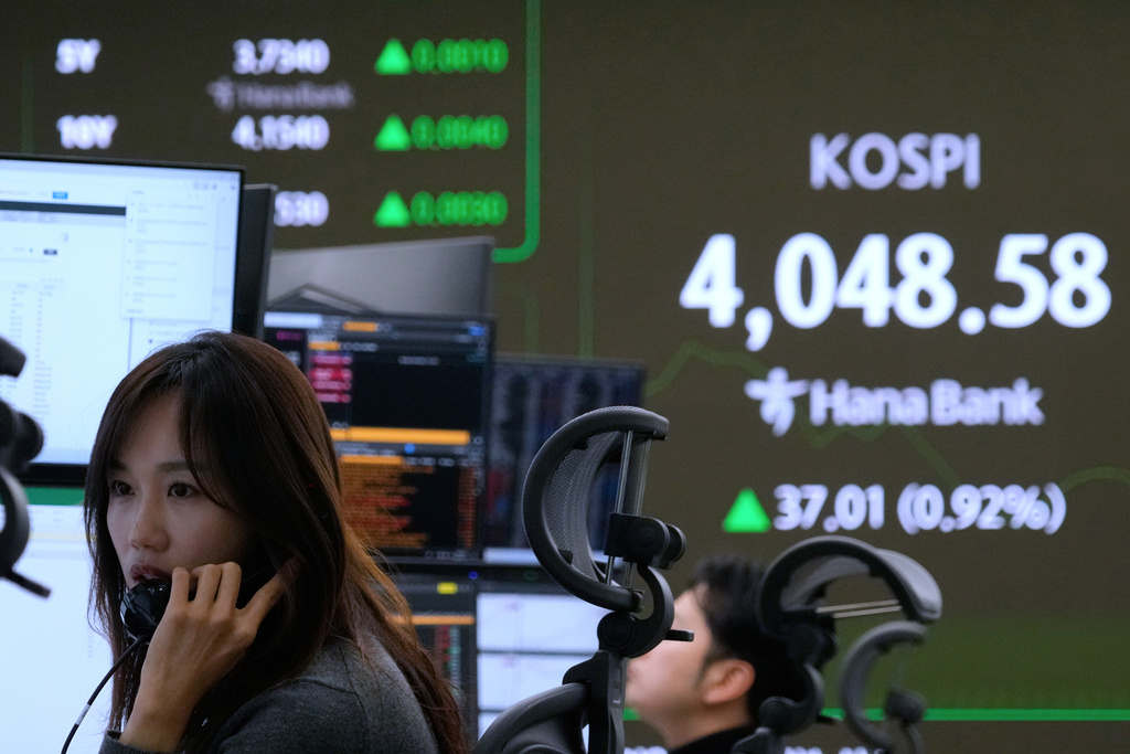 A currency trader talks on the phone near a screen showing the Korea Composite Stock Price Index (KOSPI) at the foreign exchange dealing room of the Hana Bank headquarters in Seoul, South Korea, Monday, Nov. 17, 2025. (AP Photo/Ahn Young-joon)
