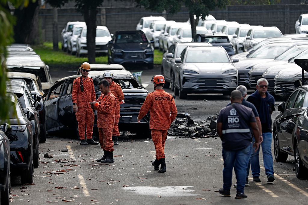 Emergency workers inspect the site where two helicopters reportedly collided in midair and crashed into a car dealership parking lot in Rio de Janeiro, Brazil, Sunday, June 14, 2026. (AP Photo/Bruna Prado)
