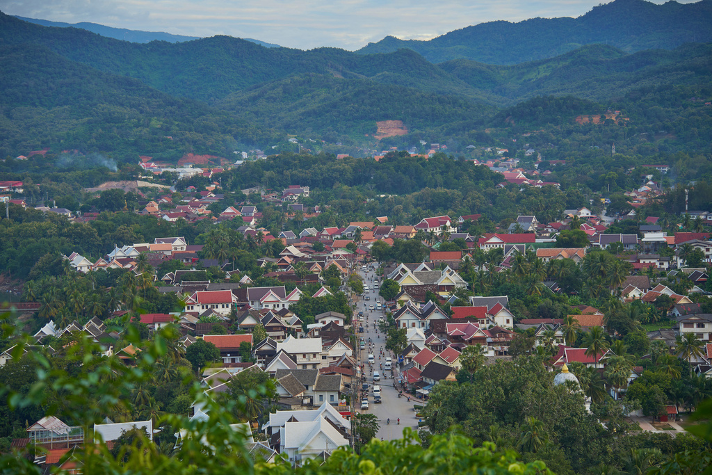 A view traditional homes and temples beneath forested mountains in Luang Prabang, Laos, Wednesday, Nov. 5, 2025. (AP Photo/Eugene Hoshiko)