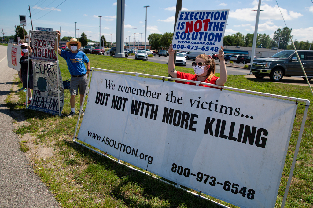 FILE - Kyle Rubin, of Columbus, Ohio, protests against the death penalty in Terre Haute, Ind., July 17, 2020. (AP Photo/Michael Conroy, File)