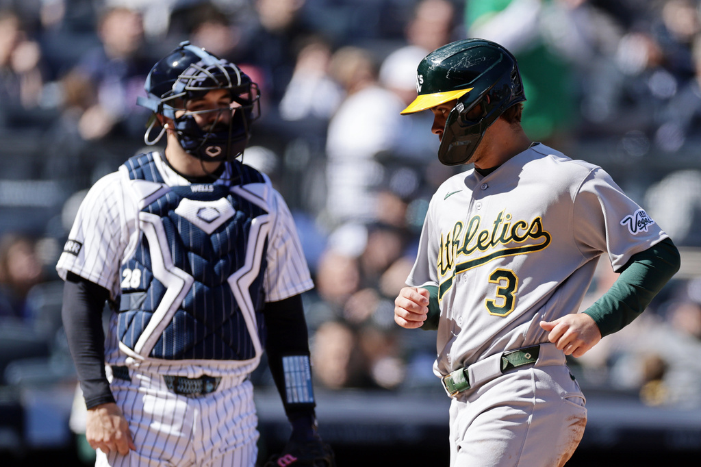 Athletics' Max Muncy (3) scores a run past New York Yankees catcher Austin Wells during the seventh inning of a baseball game Thursday, April 9, 2026, in New York. (AP Photo/Adam Hunger)