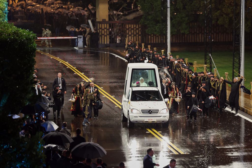 In this photo released by the Lebanese Presidency press office, Lebanese dancers, wearing folk costume, perform the traditional Lebanese "dabkeh" dance, as they welcome Pope Leo XIV in his pope mobile upon his arrival at the presidential palace in Baabda, east of Beirut, Lebanon, Sunday, Nov. 30, 2025. (Lebanese Presidency press office via AP)