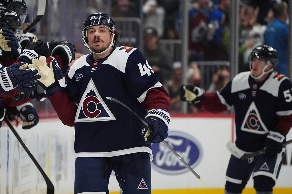 Colorado Avalanche defenseman Samuel Girard is congratulated as he passes the team box after scoring a goal against the Utah Mammoth in the second period of an NHL hockey game, Tuesday, Dec. 23, 2025, in Denver. (AP Photo/David Zalubowski)