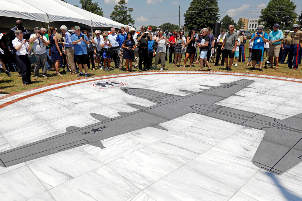 FILE - Family members and others look at a monument honoring the 15 Marines and one Navy corpsman who died in a July 10, 2017, U.S. military plane crash near Itta Bena, Miss., during an unveiling ceremony for the monument on July 14, 2018. (AP Photo/Rogelio V. Solis, File)