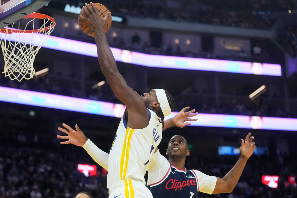 Golden State Warriors guard Buddy Hield, left, shoots against Los Angeles Clippers guard Chris Paul during the first half of an NBA basketball game in San Francisco, Tuesday, Oct. 28, 2025. (AP Photo/Jeff Chiu)
