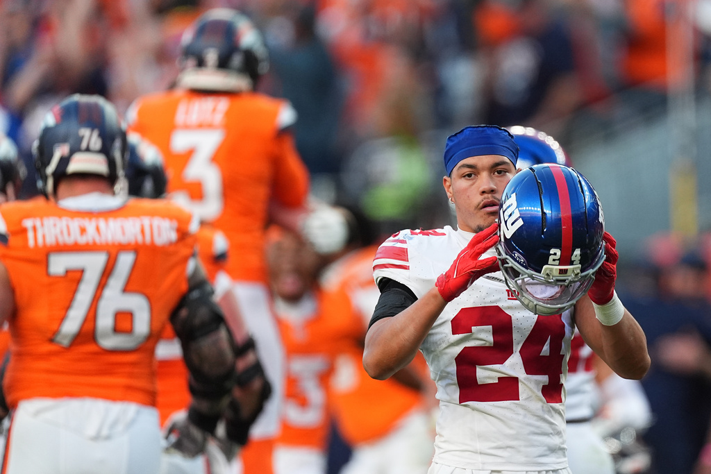 New York Giants safety Dane Belton (24) reacts as Denver Broncos players celebrate after kicker Wil Lutz (3) kicked the game winning field goal during the second half of an NFL football game in Denver, Sunday, Oct. 19, 2025. (AP Photo/David Zalubowski)