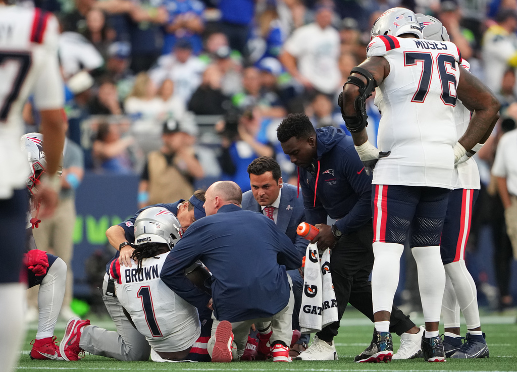 New England Patriots wide receiver A.J. Brown (1) is tended to on the field during the second half of an NFL football game against the Seattle Seahawks, Wednesday, Sept. 9, 2026, in Seattle. (AP Photo/Lindsey Wasson)