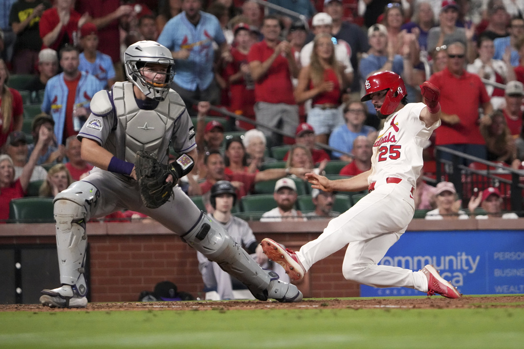 St. Louis Cardinals' Thomas Saggese (25) scores past Colorado Rockies catcher Hunter Goodman during the eighth inning of a baseball game Monday, Aug. 11, 2025, in St. Louis. (AP Photo/Jeff Roberson)