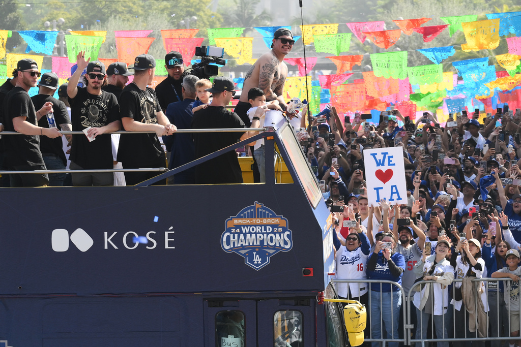 Los Angeles Dodgers players, family and staff ride on top of double-decker buses during a parade to celebrate the baseball team's World Series win on Monday, Nov. 3, 2025, in Los Angeles. (AP Photo/Kyusung Gong)