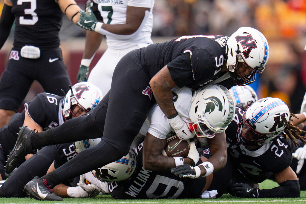 Michigan State wide receiver Nick Marsh (6) is tackled by a gaggle of Minnesota defensive players during the first half of an NCAA college football game Saturday, Nov. 1, 2025, in Minneapolis, Minn. (Alex Kormann/Star Tribune via AP)