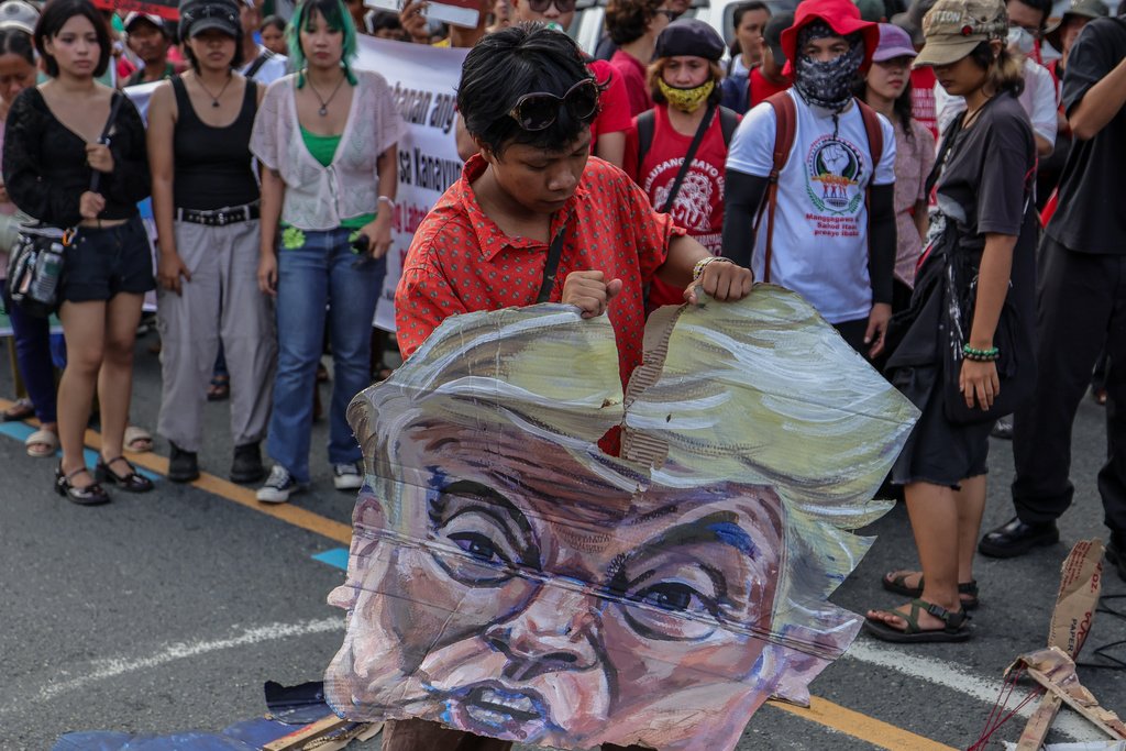 A protester destroys an effigy of U.S. President Donald Trump during a protest march in Quezon City, Philippines Monday, July 27, 2026, ahead of the State of the Nation Address by President Marcos Jr. (AP Photo/Gerard Carreon)