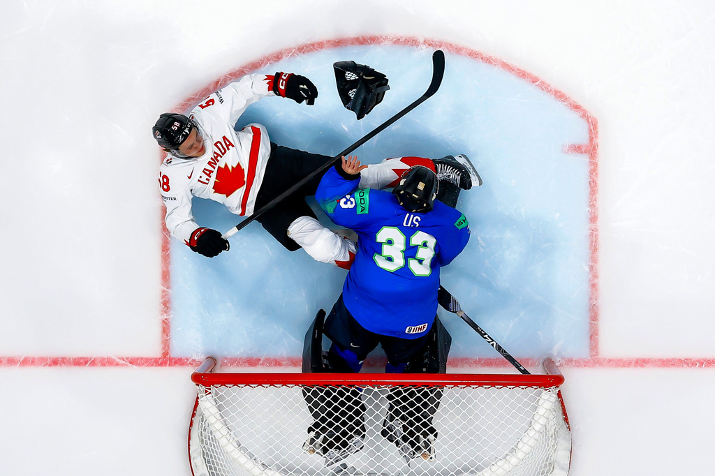 Canada's Emmitt Finnie, left, clashes against Slovenia's goaltender Zan Us, right, during a preliminary round game between Canada and Slovenia at the men's ice hockey world championship in Fribourg, Switzerland, Friday May 22, 2026. (Salvatore Di Nolfi/Keystone via AP)